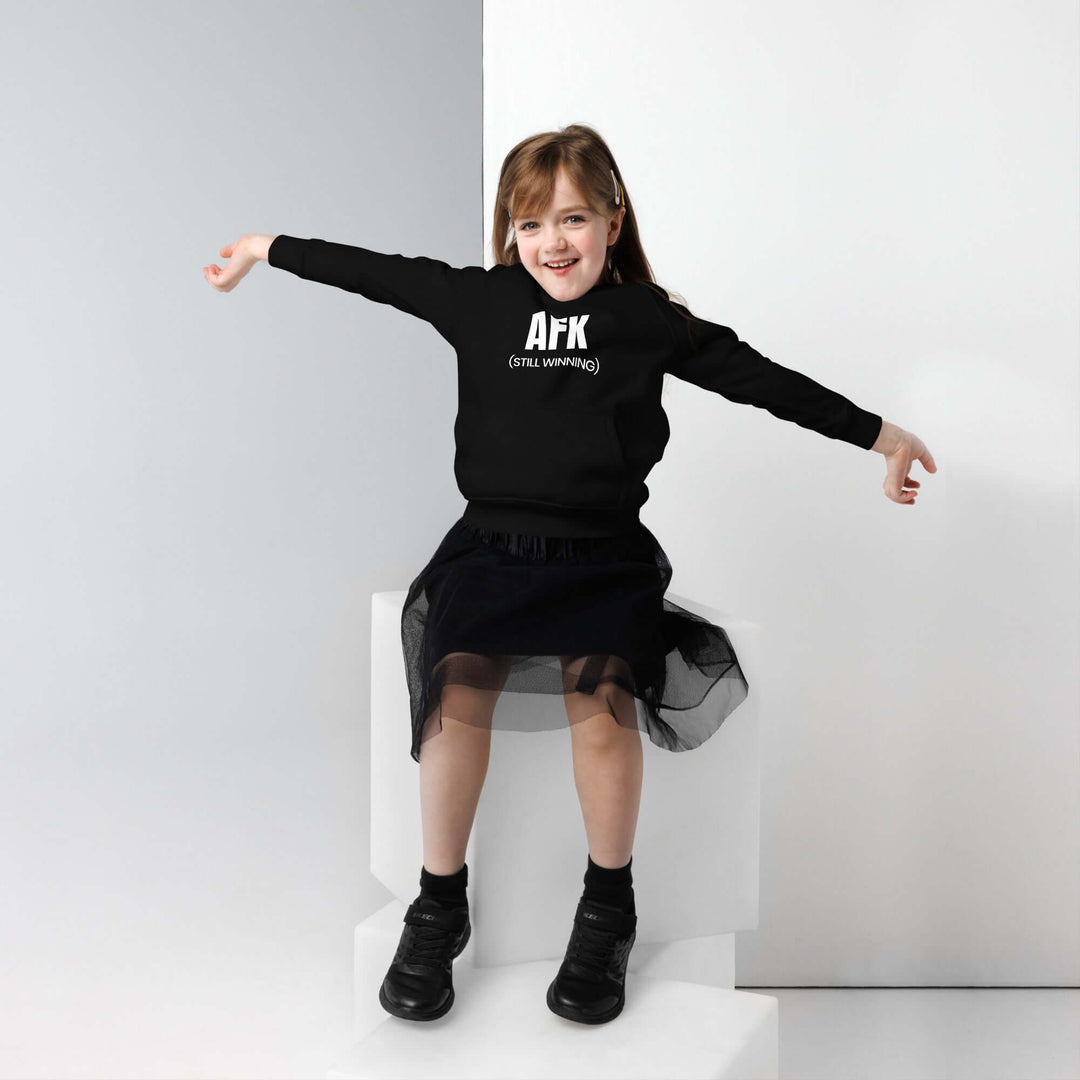 A young girl wearing a black AFK kids eco-friendly hoodie, showcasing style and comfort.