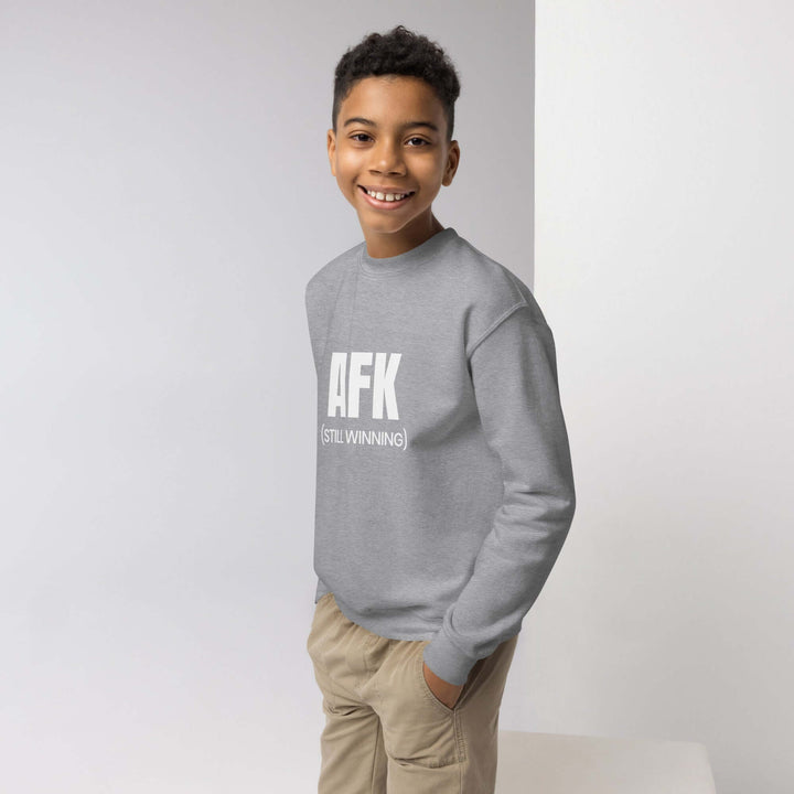 Smiling child wearing an AFK youth crewneck sweatshirt in gray, showcasing a blend of comfort and style.